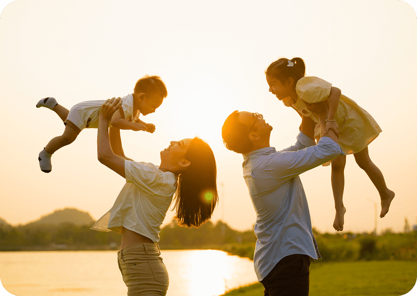 Family playing by the lake at sunset